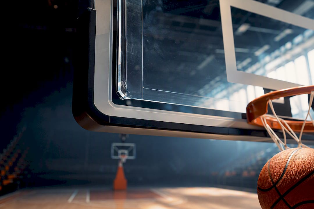 Unkenntliche Basketballkorb-Kante mit Ball in der Sporthalle