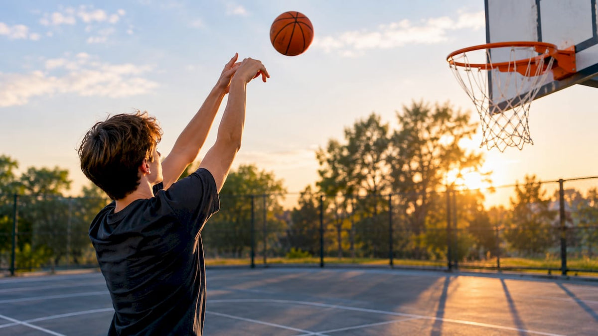Spieler wirft auf einen Basketballkorb mit Backboard