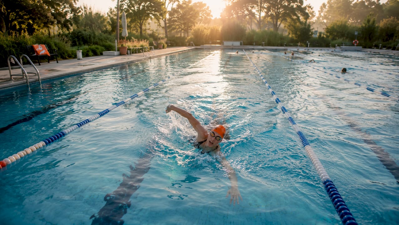 Eine Frau zieht beim Kraulen ihre Bahnen im Schwimmbad.